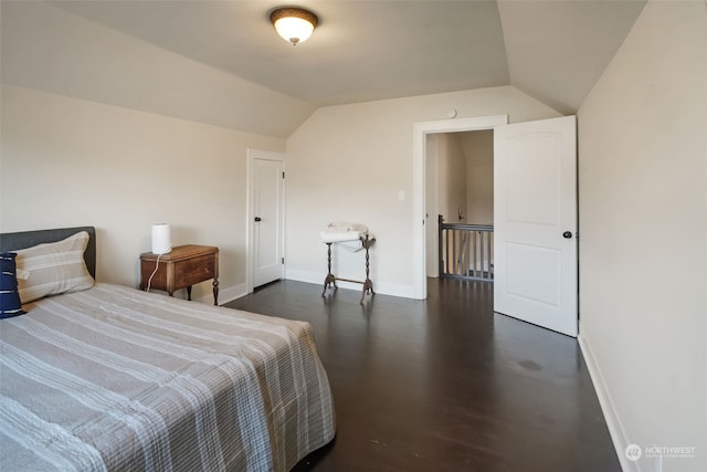 bedroom featuring dark wood-type flooring and vaulted ceiling