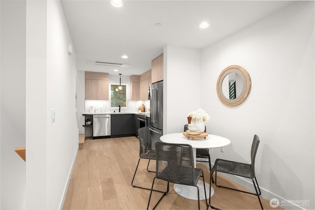 dining area featuring light wood finished floors, recessed lighting, and baseboards