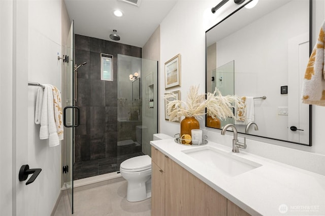 bathroom with tile patterned floors, a shower stall, toilet, and vanity