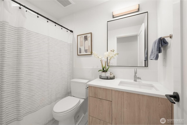 bathroom featuring vanity, toilet, and visible vents