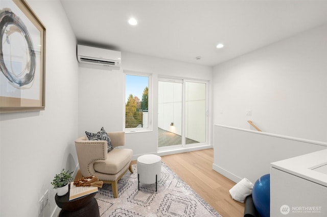 living area featuring baseboards, an upstairs landing, recessed lighting, wood finished floors, and a wall mounted AC