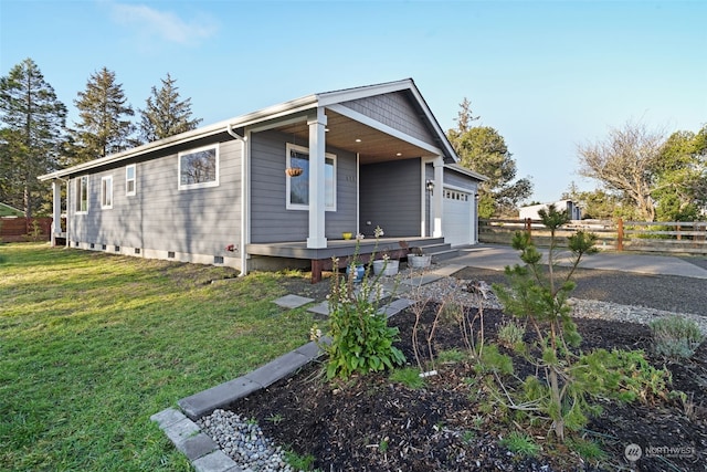 view of front facade featuring a front lawn, covered porch, and a garage