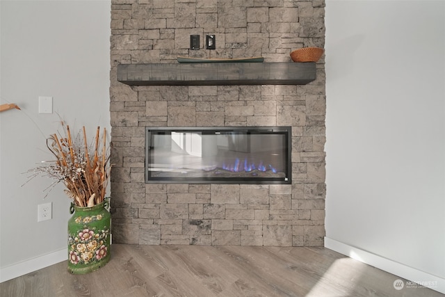 interior details with hardwood / wood-style floors and a stone fireplace