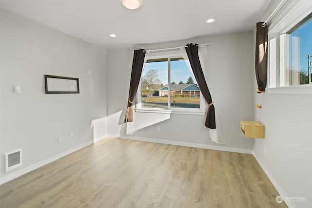 spare room with a healthy amount of sunlight and light hardwood / wood-style floors