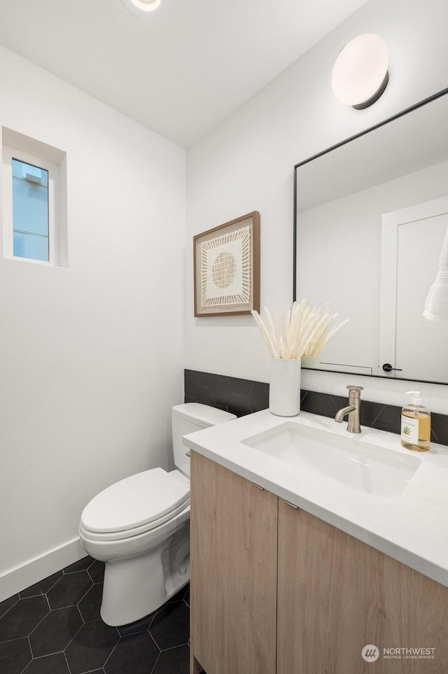 bathroom with toilet, tile patterned flooring, and vanity