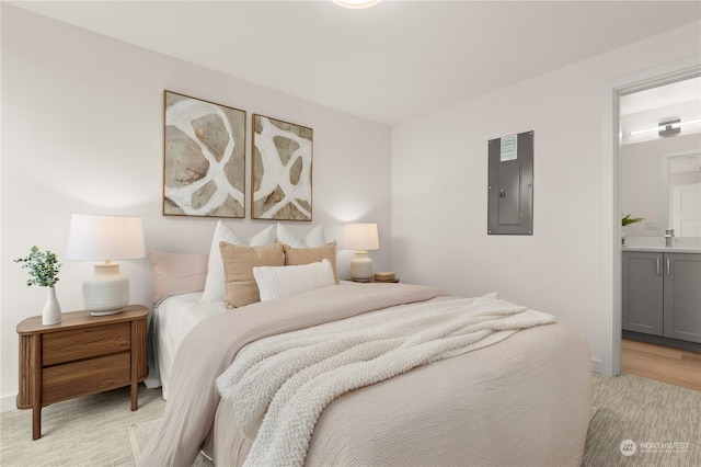 bedroom featuring sink, electric panel, and ensuite bath