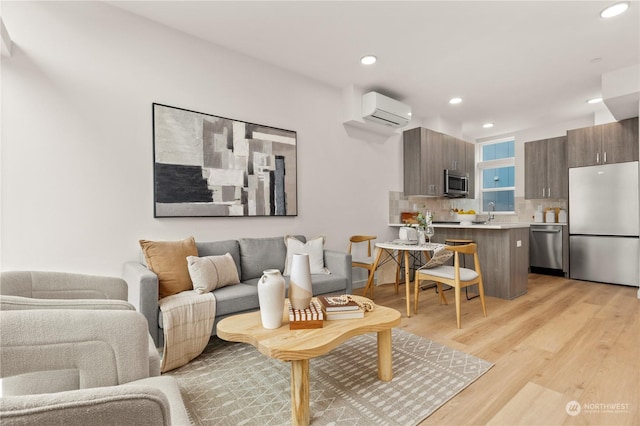 living room featuring light hardwood / wood-style flooring and an AC wall unit