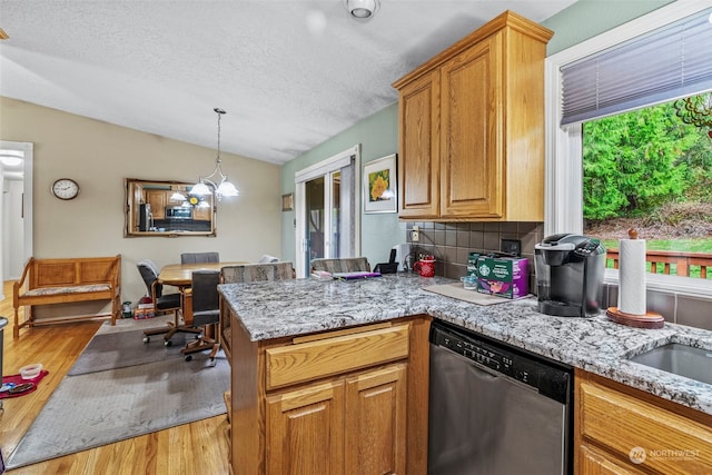 kitchen featuring decorative backsplash, dishwasher, light hardwood / wood-style floors, and a textured ceiling