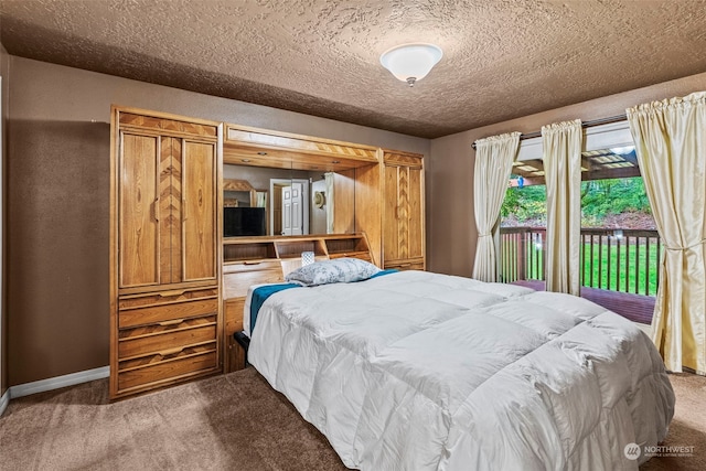 bedroom with carpet flooring, a textured ceiling, and access to outside