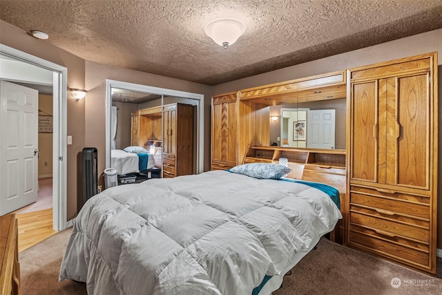 bedroom featuring carpet flooring, a closet, and a textured ceiling