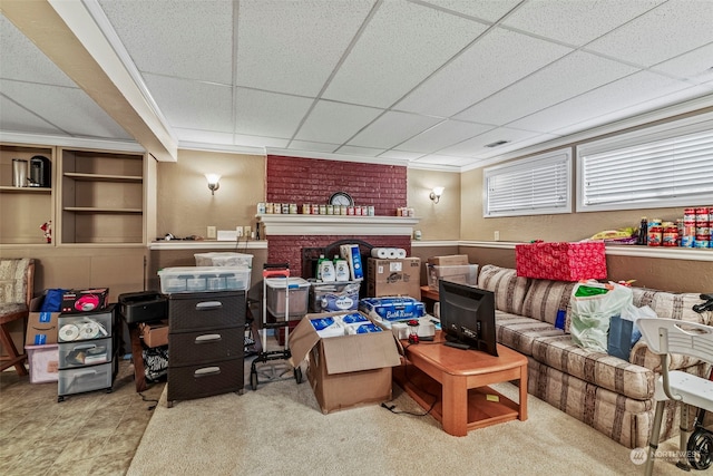 living room featuring a drop ceiling and crown molding