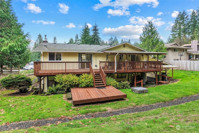 rear view of house featuring a yard and a deck