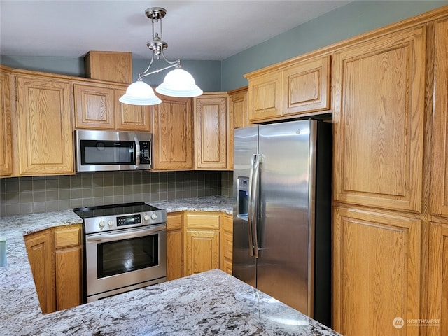 kitchen featuring light stone countertops, appliances with stainless steel finishes, backsplash, and decorative light fixtures