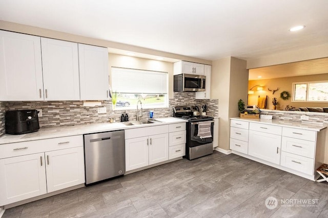 kitchen with sink, white cabinets, a healthy amount of sunlight, and appliances with stainless steel finishes