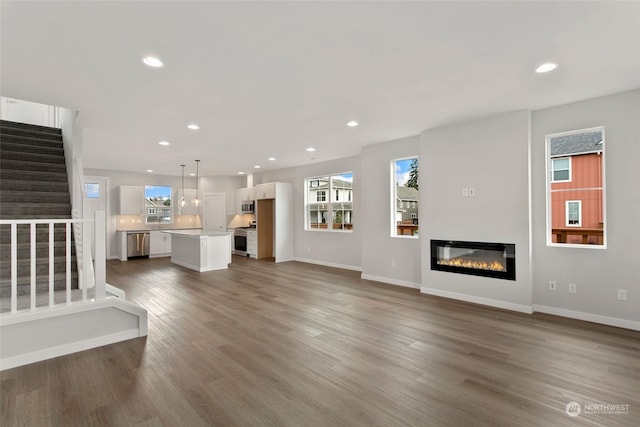 unfurnished living room with dark hardwood / wood-style floors and a wealth of natural light