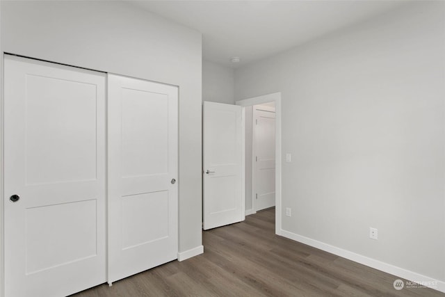 unfurnished bedroom with wood-type flooring and a closet