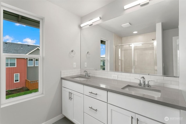 bathroom featuring walk in shower, vanity, and tasteful backsplash