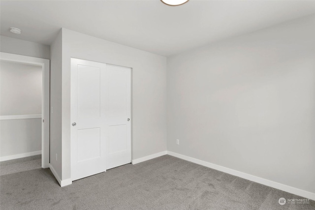 unfurnished bedroom with light carpet and a closet