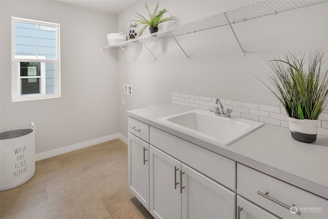 clothes washing area with washer hookup, sink, and cabinets