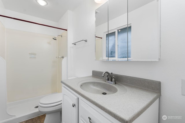 bathroom featuring vanity, toilet, and walk in shower