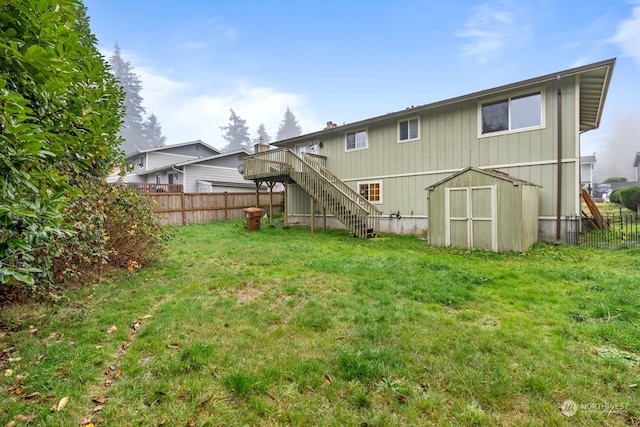 rear view of house with a storage unit, a wooden deck, and a lawn