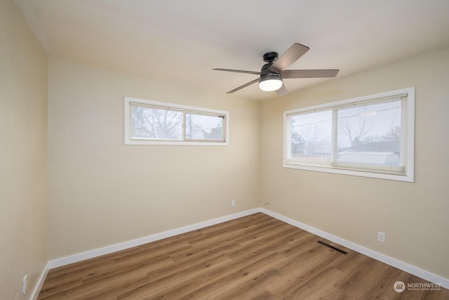 unfurnished room with ceiling fan and hardwood / wood-style flooring