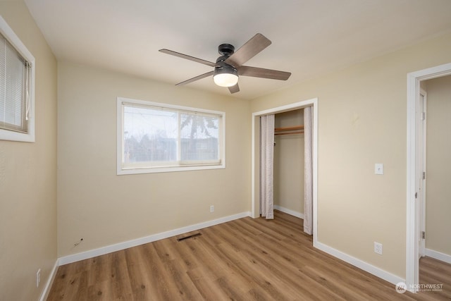 unfurnished bedroom with ceiling fan, light wood-type flooring, and a closet