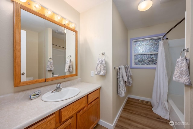 full bathroom featuring hardwood / wood-style floors, vanity, toilet, and shower / bath combo with shower curtain