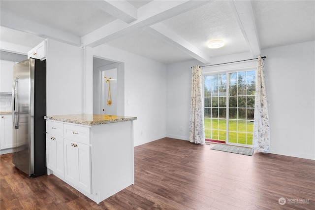 kitchen with white cabinets, dark hardwood / wood-style floors, stainless steel fridge, and light stone counters