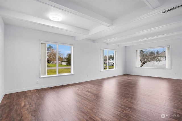 spare room featuring beam ceiling and dark wood-type flooring