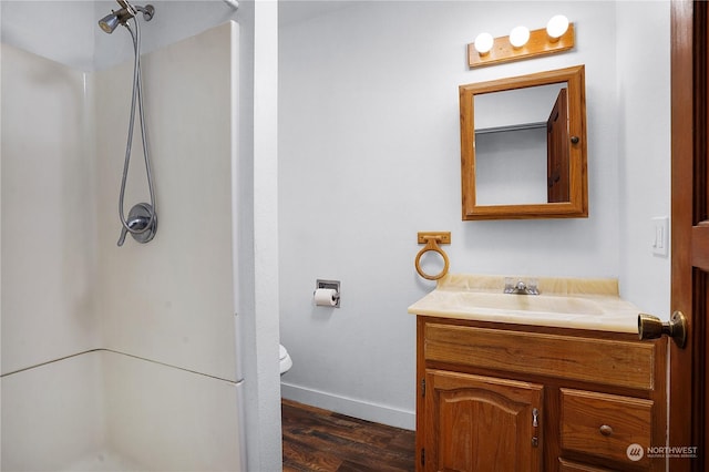 bathroom featuring hardwood / wood-style floors, vanity, toilet, and walk in shower