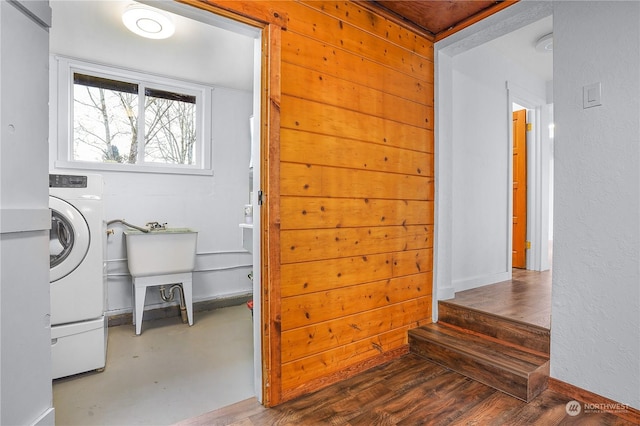 clothes washing area featuring washer / dryer, hardwood / wood-style flooring, and wood walls