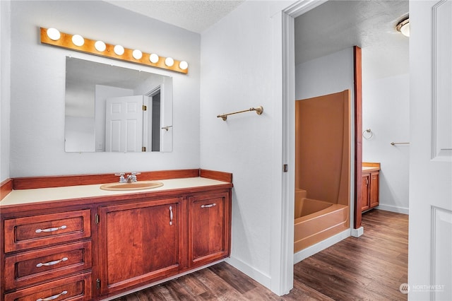 bathroom with a textured ceiling, vanity, and hardwood / wood-style flooring