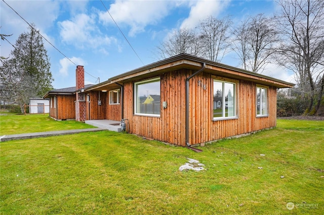 view of side of home with a yard