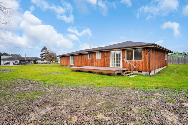 back of property featuring a wooden deck and a yard