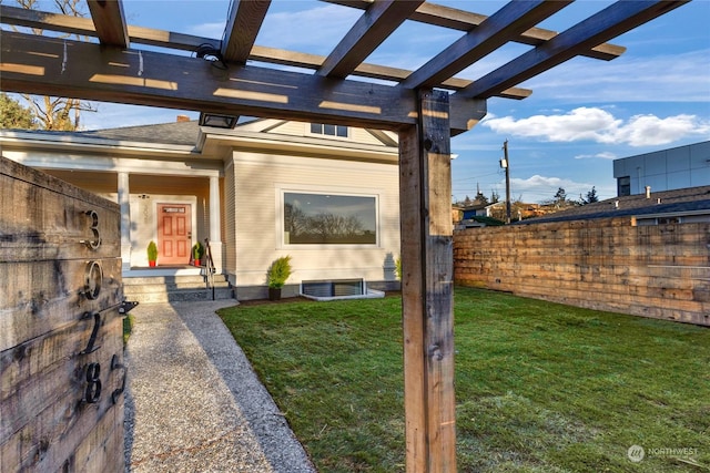 view of exterior entry featuring a pergola and a yard