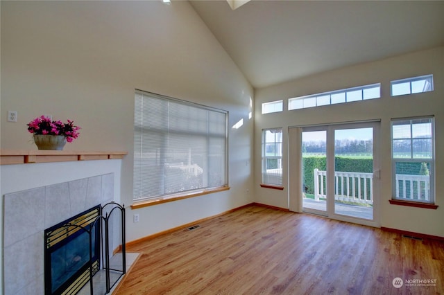 living room featuring a fireplace, high vaulted ceiling, and hardwood / wood-style flooring