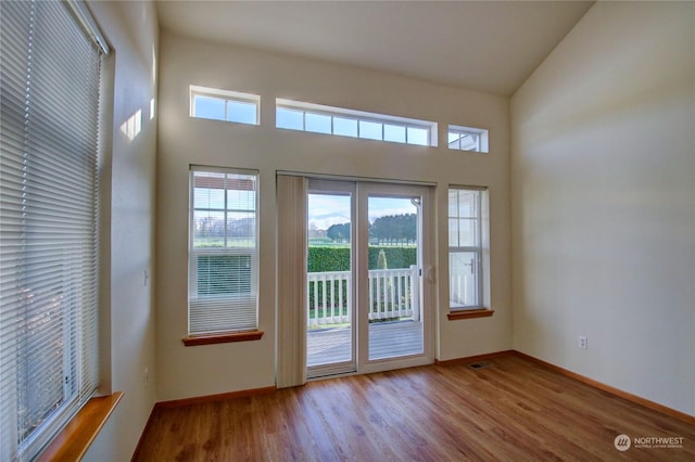 entryway with high vaulted ceiling and light hardwood / wood-style flooring