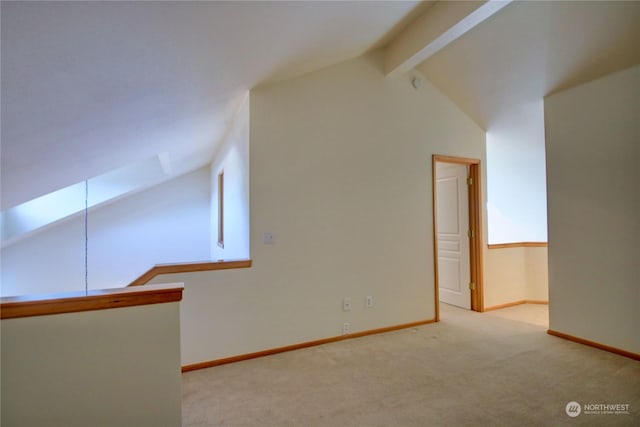 additional living space featuring vaulted ceiling with beams and light colored carpet