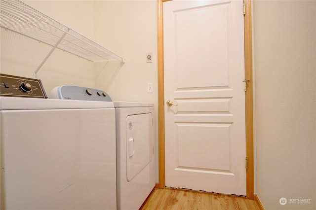 clothes washing area featuring light wood-type flooring and washing machine and clothes dryer