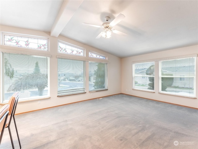 interior space with vaulted ceiling with beams, ceiling fan, light colored carpet, and plenty of natural light