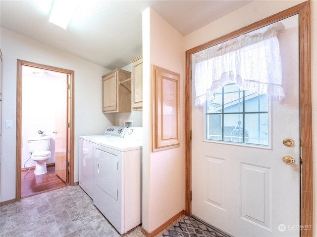 laundry room featuring cabinets, washer and clothes dryer, and plenty of natural light