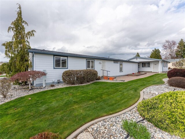 view of front of property featuring a front lawn and a patio