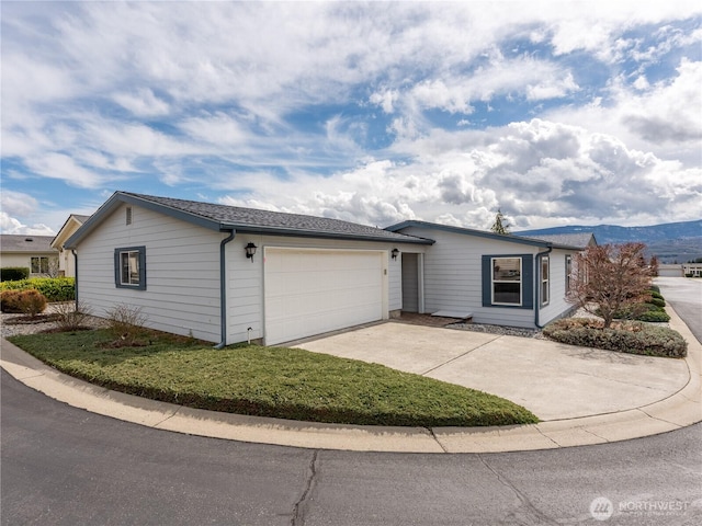 single story home with a mountain view, concrete driveway, and a garage