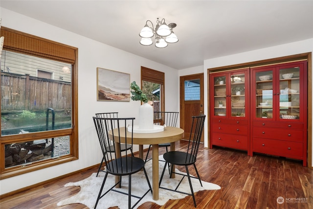 dining space featuring dark hardwood / wood-style floors and a chandelier