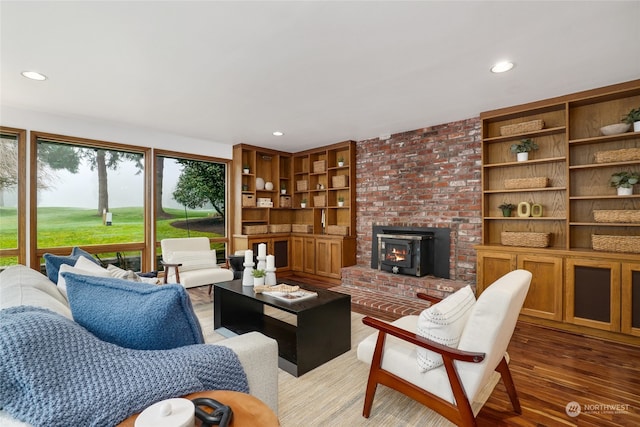 living room featuring hardwood / wood-style flooring, a wood stove, and built in shelves