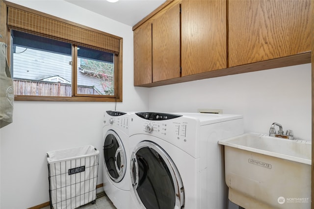 laundry area with washing machine and dryer, sink, and cabinets