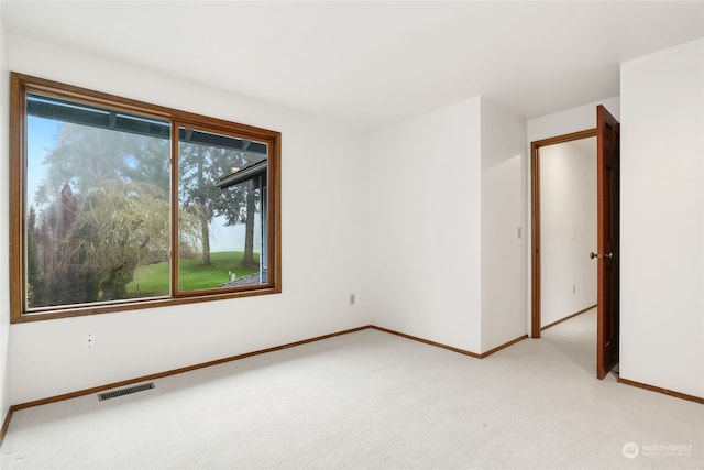 unfurnished room featuring light carpet