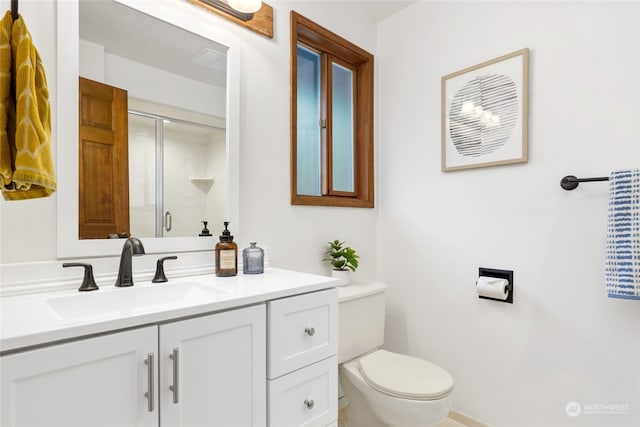 bathroom featuring toilet, vanity, and walk in shower