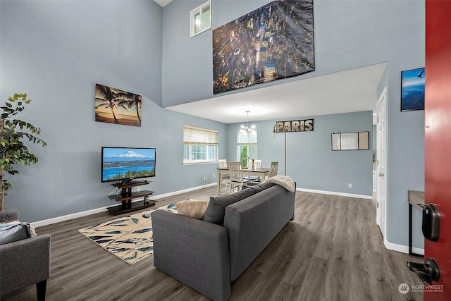 living room with dark hardwood / wood-style floors and an inviting chandelier